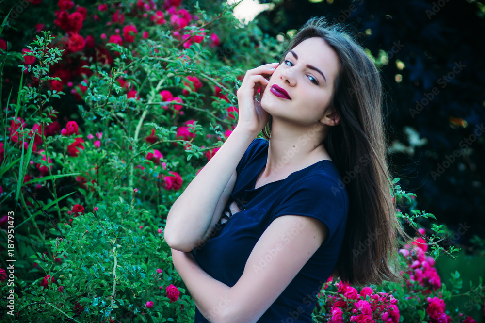 Girl model in black T-shirt near roses Girl model in black T-shirt near roses
