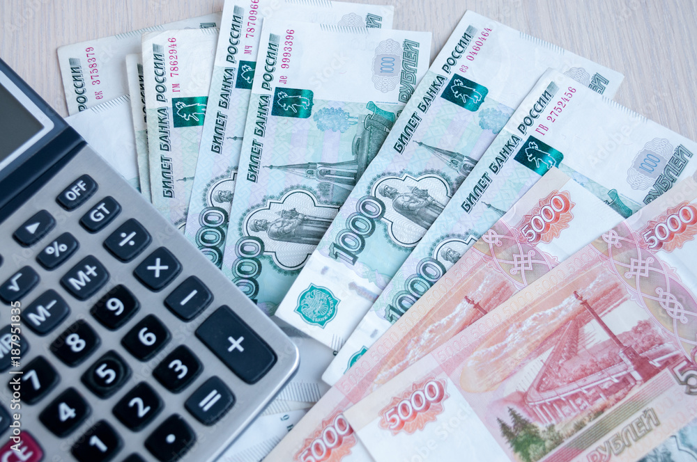 On the table there are money Russian rubles and a calculator. Calculation of profit On the table there are money Russian rubles and a calculator. Calculation of profit