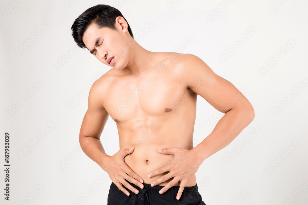 Man with stomachache feeling pain. Studio shot on white background. Fitness and health concept Man with stomachache feeling pain. Studio shot on white background. Fitness and health concept