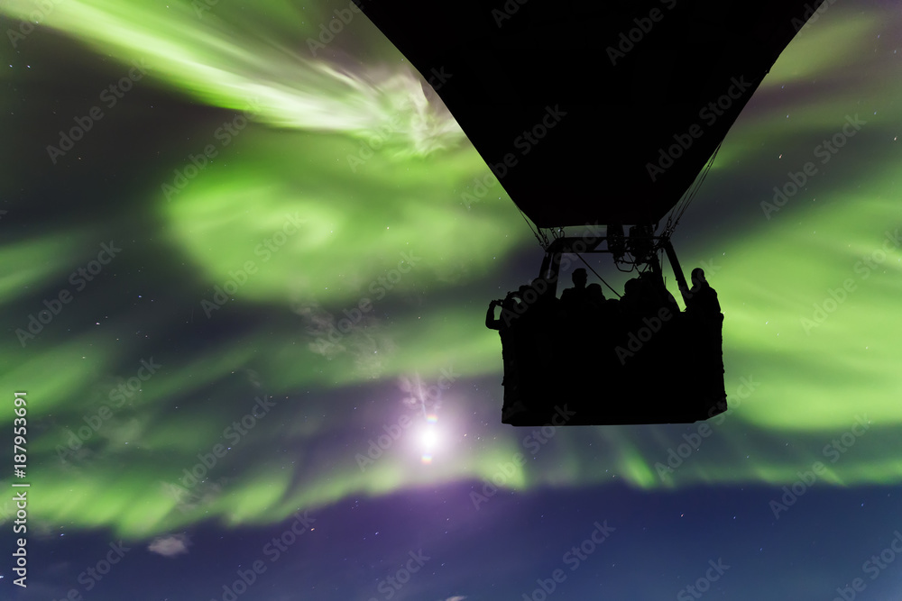 Naklejka premium Hot air balloon on a background of the Northern Lights