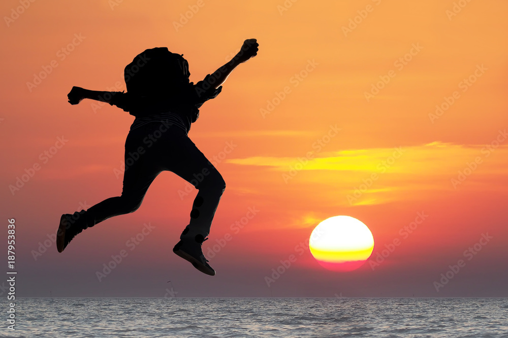 Silhouette Happy man Jumping in Sea Sunset