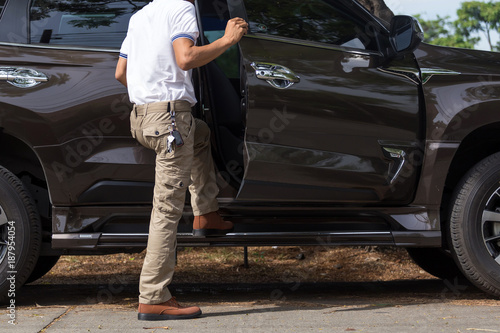 Man wearing cargo pants with suv car parking in the nature park