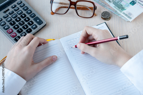 The girl writes in a notebook at the table