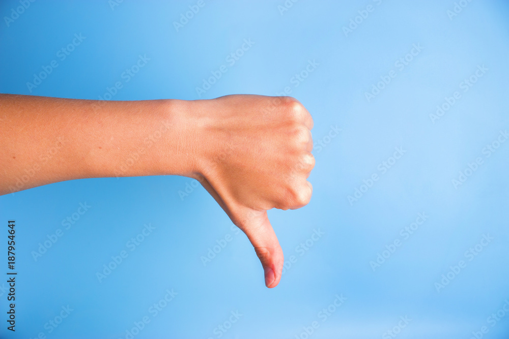 Closeup of woman's hand gesturing thumbs down