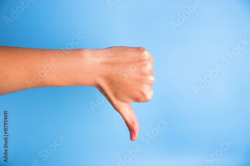 Closeup of woman's hand gesturing thumbs down
