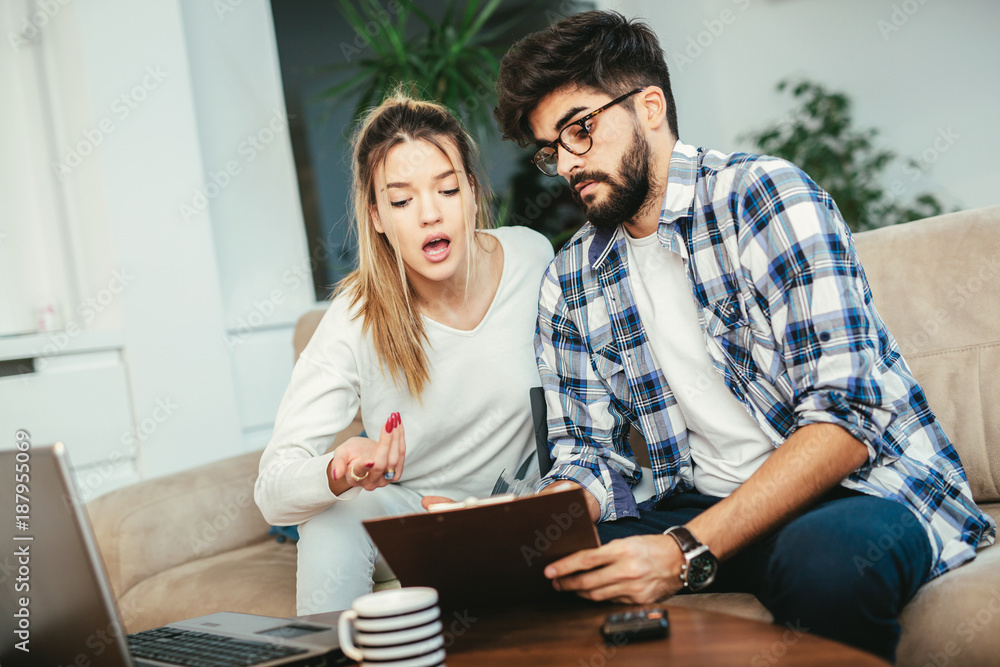 Woman and man doing paperwork together, paying taxes online on notebook pc Woman and man doing paperwork together, paying taxes online on notebook pc
