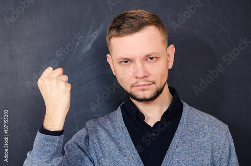 A bearded man look shows a gesture a clenched fist