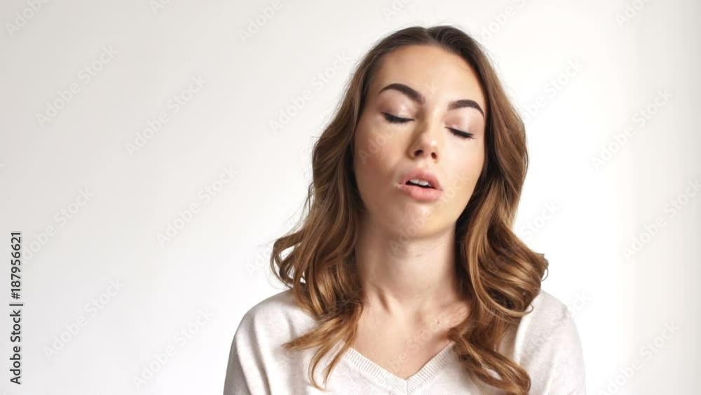 Close up view of confused brunette woman waiting something and looking at wristwatch over grey background Close up view of confused brunette woman waiting something and looking at wristwatch over grey background