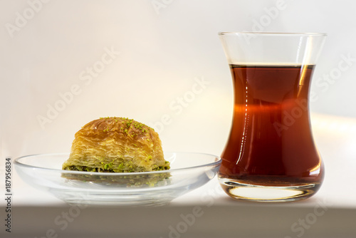 Baklava with pistachio and turkish cup of tea on a white background