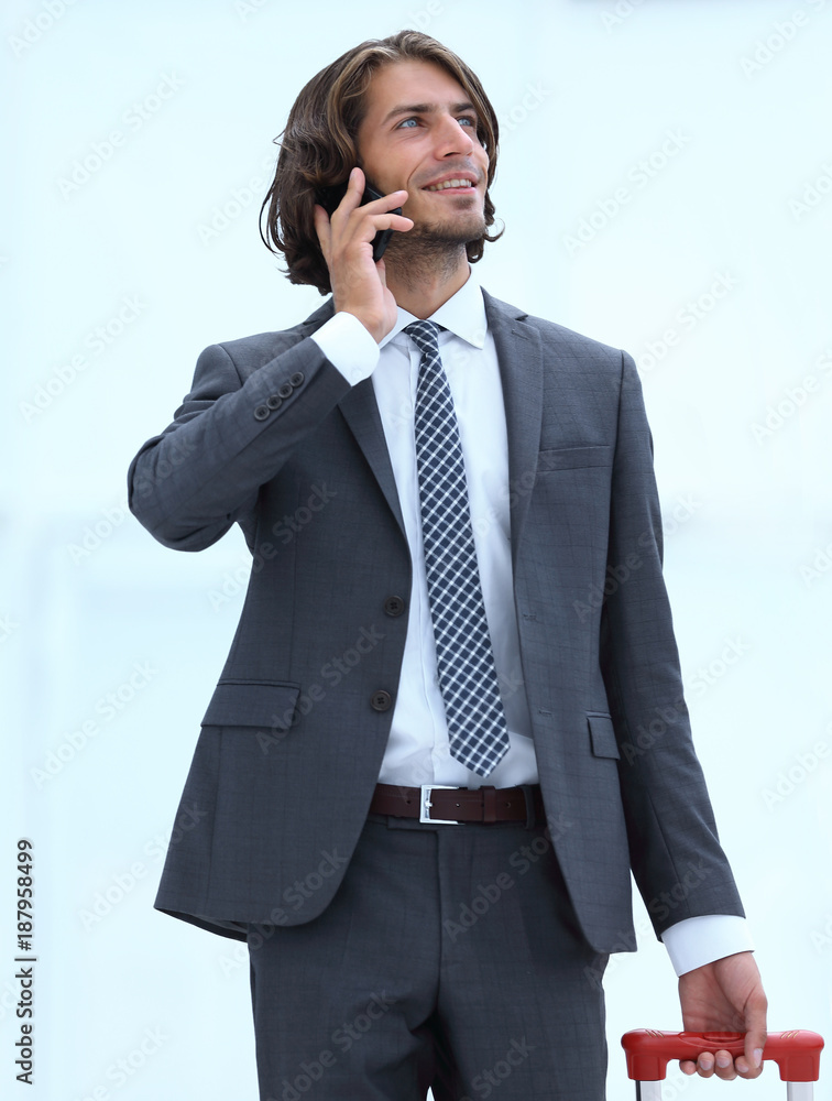 businessman with travel suitcase talking on the phone businessman with travel suitcase talking on the phone
