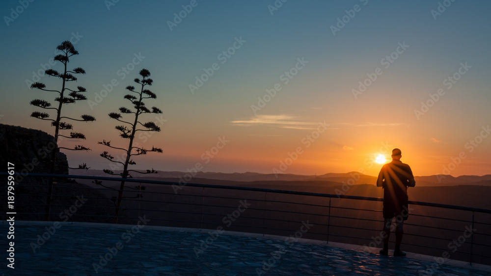 Silhouette man who is watching sunset from viewpoint on Gran Canaria island. Silhouette man who is watching sunset from viewpoint on Gran Canaria island.