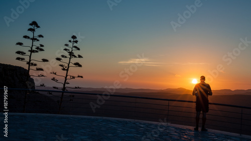 Silhouette man who is watching sunset from viewpoint on Gran Canaria island.