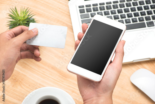 Businessman holding hand credit card and using smartphone.