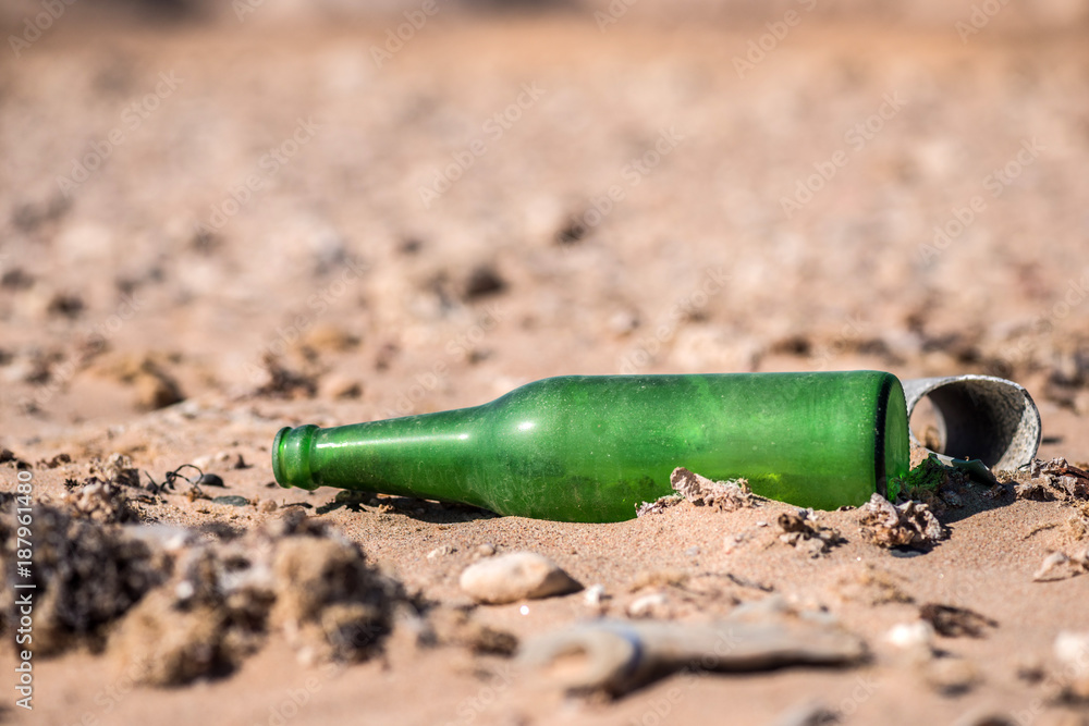 old green empty glass bottle on the sand. Macro. old green empty glass bottle on the sand. Macro.