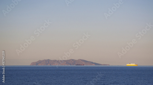 Corsica, 03/09/2017: un traghetto al tramonto e il profilo di Capraia, piccola isola vulcanica nel canale della Corsica, visti dal Capo Corso