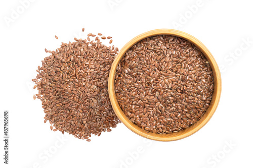 Linseed or flax seed in a wooden bowl and a pile next to it seen from above isolated on white background