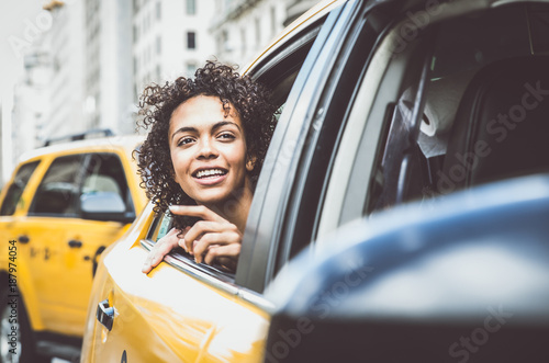 Fotografia Happy afro american woman on a yellow cab