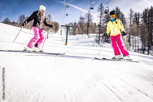 Friends skiing and snowboarding on the snow tracks