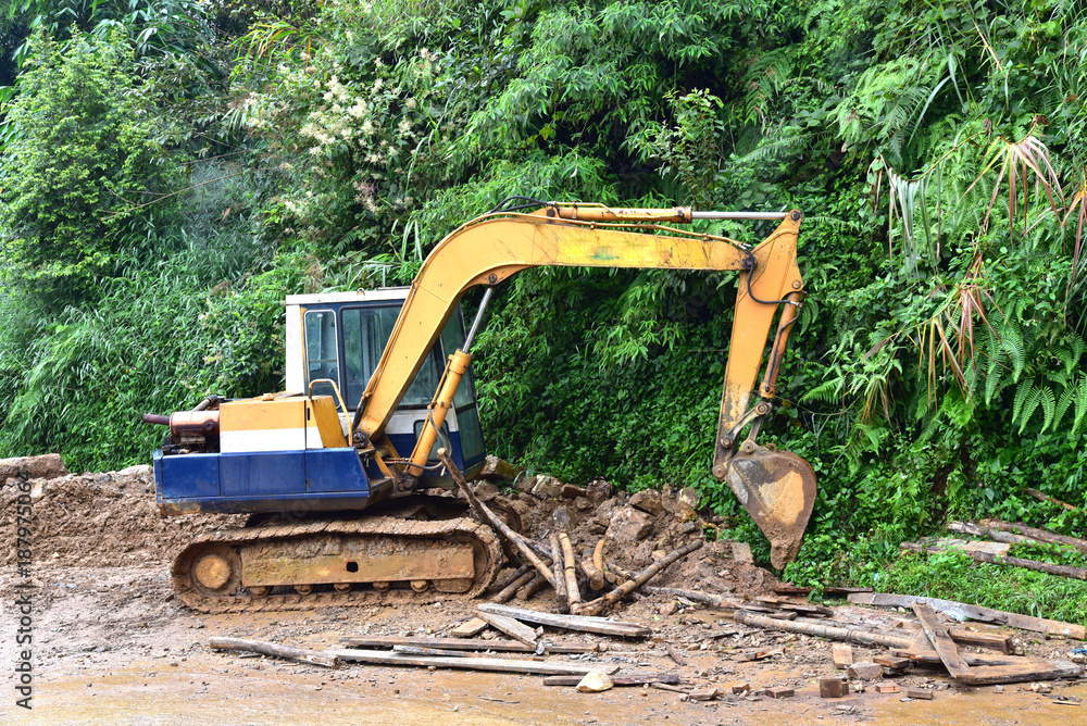 View of backhoe was digging a pit in the ground for rainwater,Crawler  excavator truck ,Construction digger machine in flat. Backhoe loader, Heavy  equipment. Backhoe working at construction side. Photos | Adobe Stock