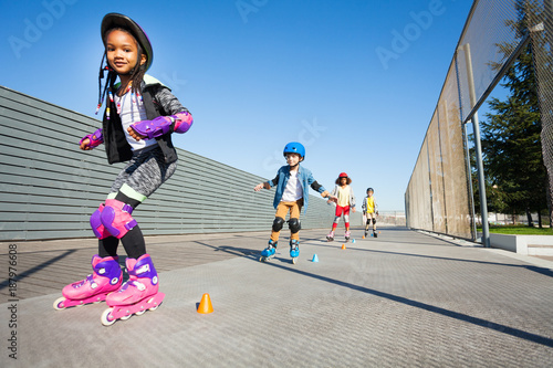 Cute African girl learning to rollerblade outdoor