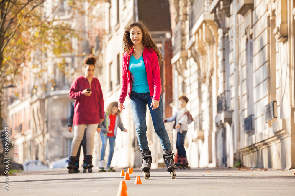 Teenage girl rollerblading around the cones
