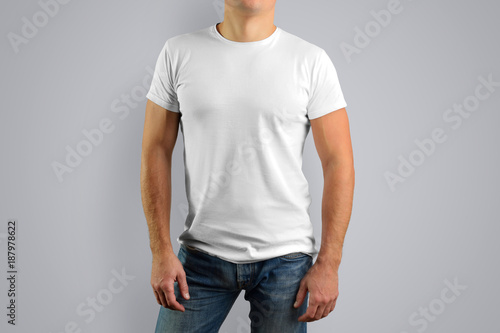 man in a white t-shirt is isolated on a gray background.