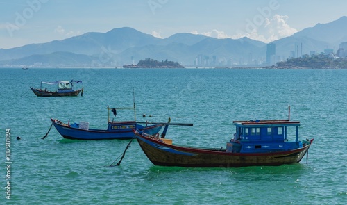 Vietnamese coastline looking out over the south china sea in Nha Trang Vietnam with a turquoise ocean and fishing boats. © Paul Hampton