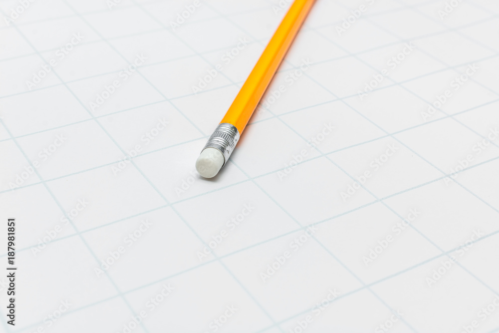Yellow pencil with eraser lies on the paper in the cage for school. Yellow pencil with eraser lies on the paper in the cage for school.