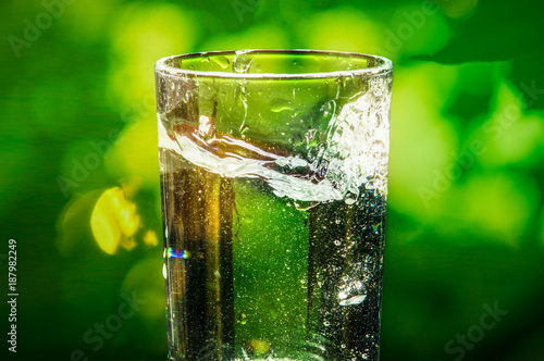 glass with water splash and blurred background