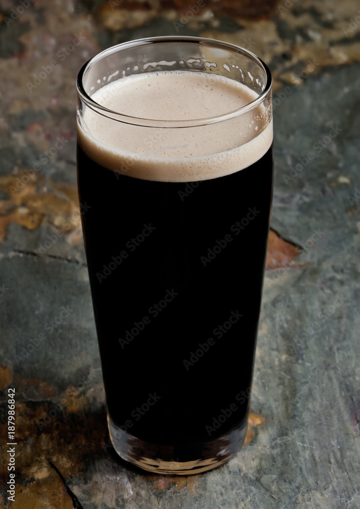 Glass of stout beer top with white foam Glass of stout beer top with white foam