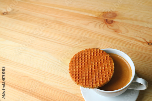 Hot Coffee with Stroopwafel Placed on Top of the Cup Served on Wooden Table, with Free Space for Text or Design 