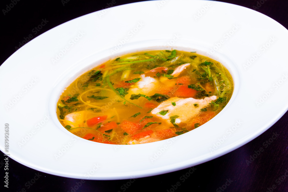 Fish soup with vegetables and herbs in white plate Fish soup with vegetables and herbs in white plate