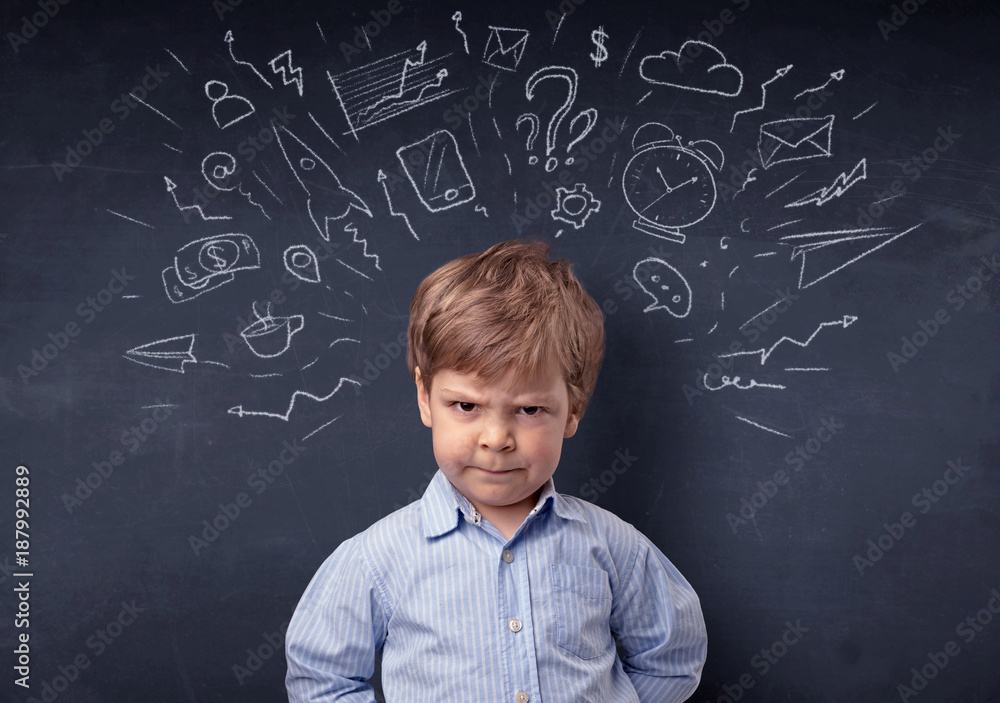 Little boy in front of a drawn up blackboard