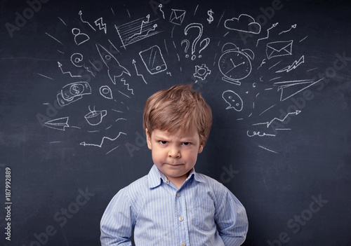 Little boy in front of a drawn up blackboard