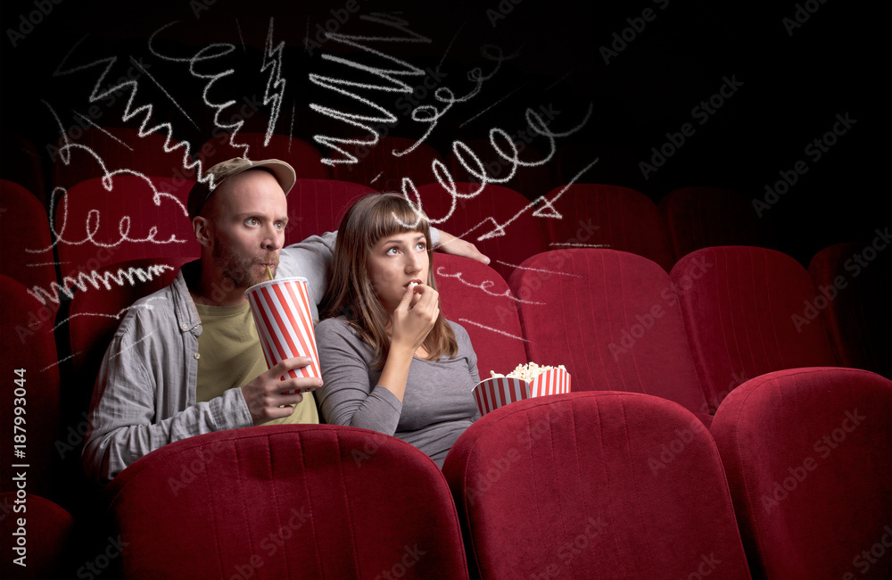 Naklejka premium Cute couple in cinema watching movie