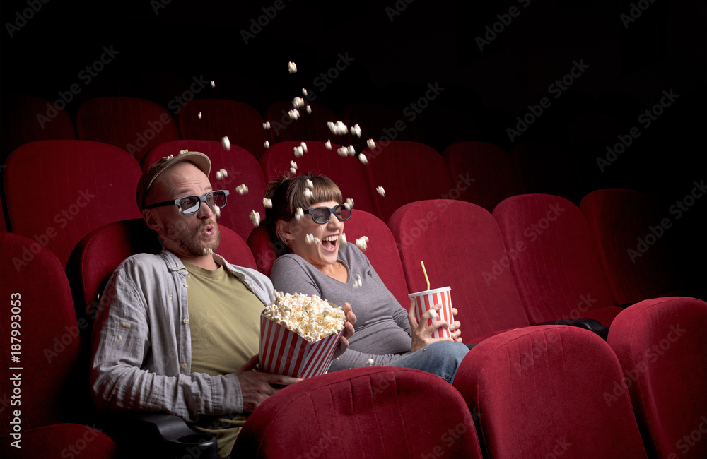 Young couple sitting at red movie theatre