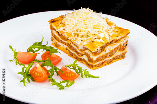 Traditional italian lasagna with beef meat and cheese on white plate