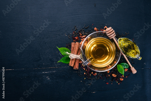 Tea in a cup of cinnamon and honey on a wooden background. Hot drink Top view. Copy space.