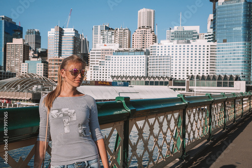 Darling Harbour district area with people on the promenade, boats near the docs and city skyline view. Sydney, Australia. August 30, 2017 photo