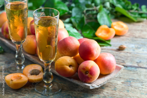 Juicy apricots with leaves and sweet wine .
