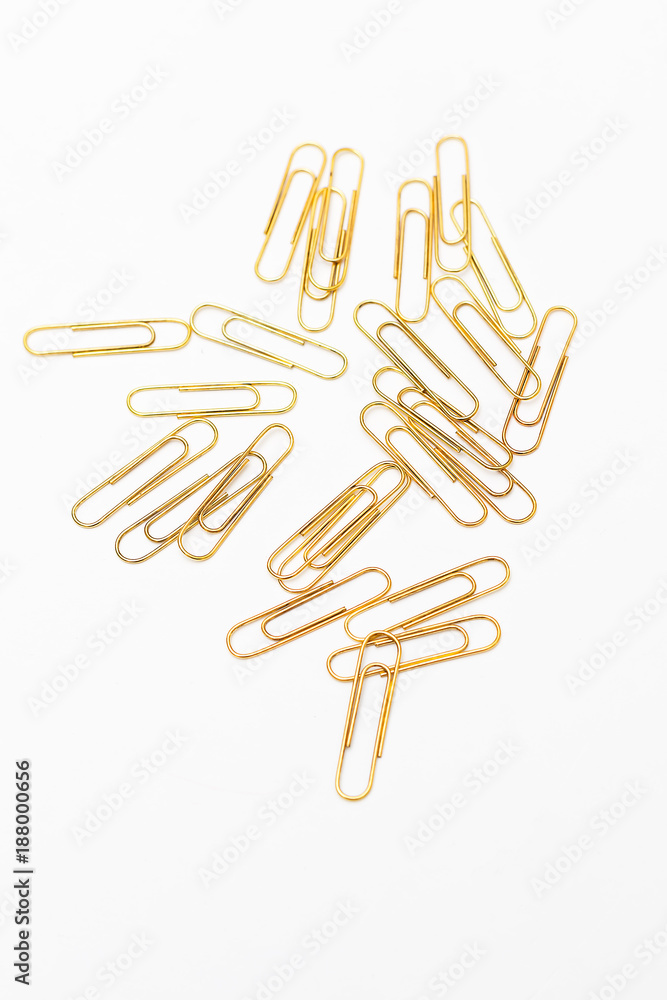 Stationery vertical. Golden paper clips on paper on white background Stationery vertical. Golden paper clips on paper on white background