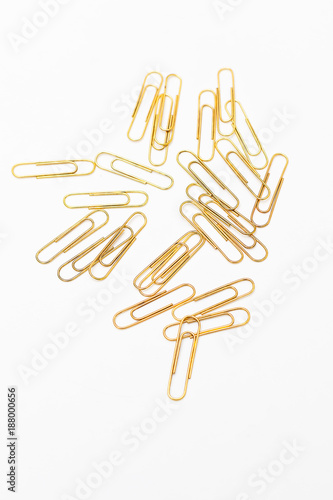 Stationery vertical. Golden paper clips on paper on white background
