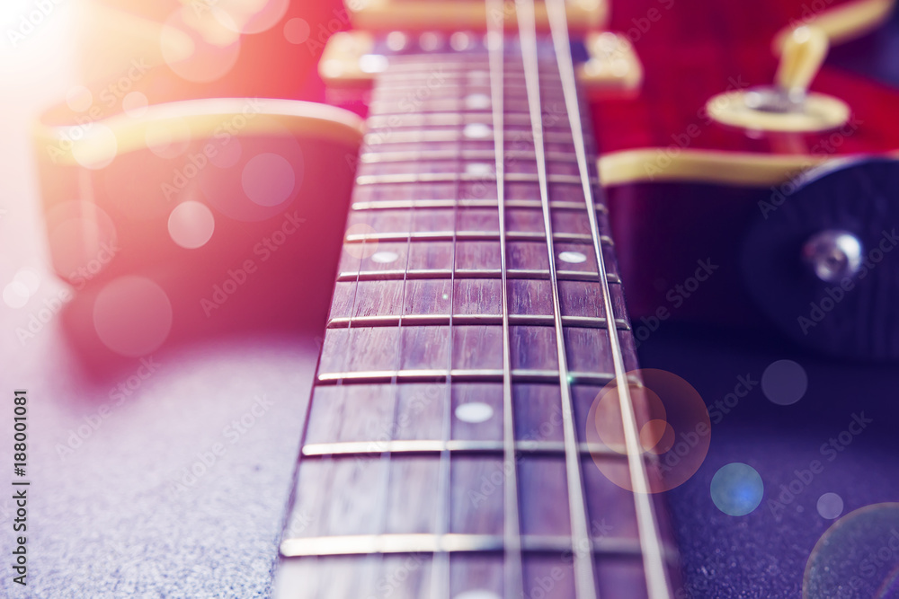 Red electric guitar close-up. Music concept. Vintage guitar on a background of sunlight and bokeh.