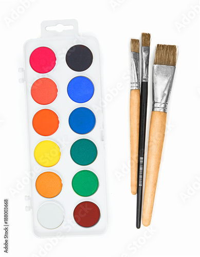 New palette of watercolour with several paint brushes isolated on the white background with no shadow reflection. Art palette with “aquarellum atramento” ink and brushes. Aquarelle paints color palet