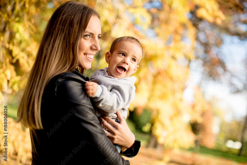 Young mother and baby boy in autumn park Young mother and baby boy in autumn park