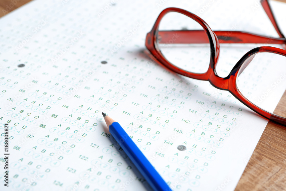 Exam form, pencil and student's eyeglasses on table Exam form, pencil and student's eyeglasses on table