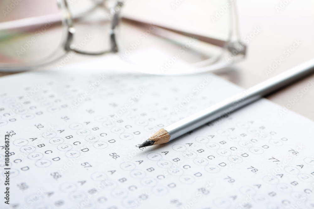 Exam form, pencil and student's eyeglasses, closeup Exam form, pencil and student's eyeglasses, closeup
