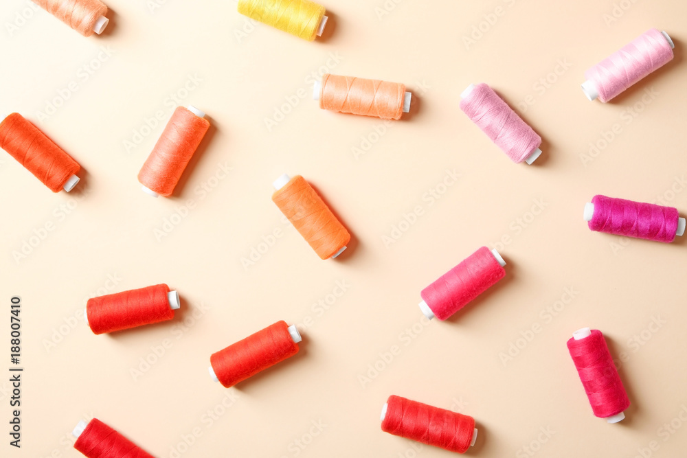 Set of sewing threads on color background, top view Set of sewing threads on color background, top view