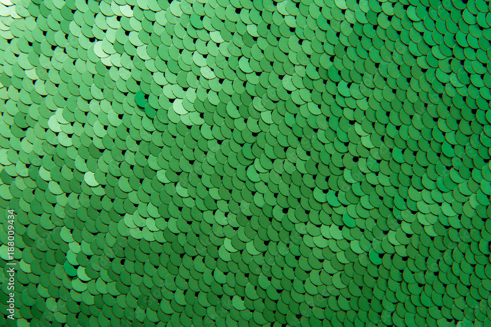 Texture of green color sequins close-up macro abstract background. Fashionable expensive fabric with sequins. Texture of green color sequins close-up macro abstract background. Fashionable expensive fabric with sequins.