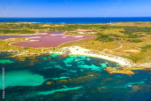 Aerial view of Pink lake and coastline of Rottnest Island in Australia. Scenic flight over famous tourist destination of Western Australia. Rottnest Island is located near Fremantle and Perth.